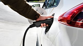 Una persona che ricarica un'auto elettrica