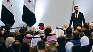 Временный президент Сирии Ахмад аль-Шараа (справа) покидает трибуну после выступления на конференции по национальному диалогу в Народном дворце в Дамаске, 25 февраля 2025 года.