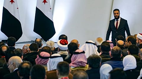 Syria's interim president Ahmad al-Sharaa, right, leaves the podium after speaking during Syria's national dialogue conference at the People’s Palace in Damascus, Feb 25 2025.
