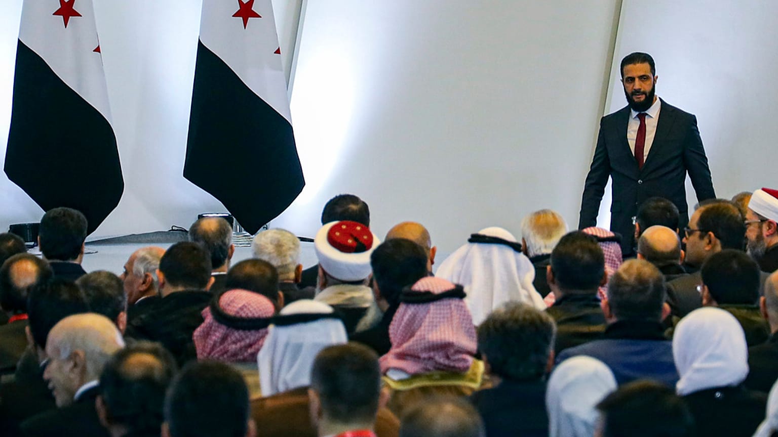 Tymczasowy prezydent Syrii, Ahmad al-Sharaa, po prawej, opuszcza mównicę po wygłoszeniu przemówienia podczas Konferencji Dialogu Narodowego Syrii w Damaszku, 2025 r.