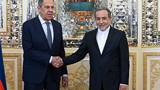  وزير الخارجية الروسي سيرغي لافروف، إلى اليسار، ووزير الخارجية الإيراني عباس عراقجي يتصافحان خلال اجتماعهما في طهران، إيران، الثلاثاء، 25 فبراير/شباط 2025