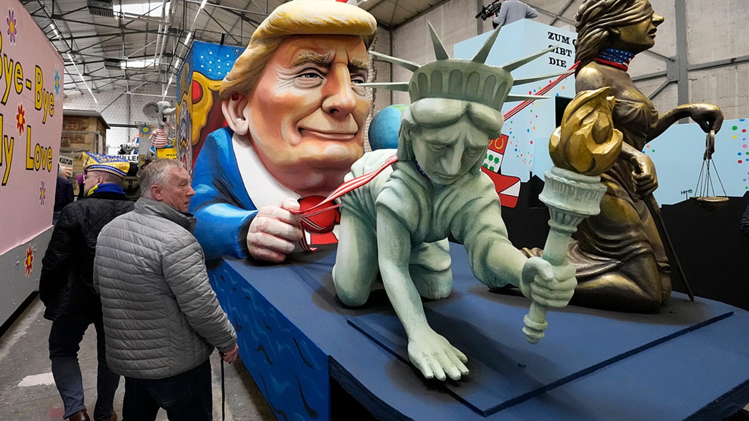 Un carro di carnevale raffigura la Statua della Libertà e Lady Justice al guinzaglio del presidente Trump durante la presentazione dei carri satirici per la Rose Monday Parade