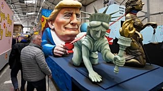 Un carro di carnevale raffigura la Statua della Libertà e Lady Justice al guinzaglio del presidente Trump durante la presentazione dei carri satirici per la Rose Monday Parade