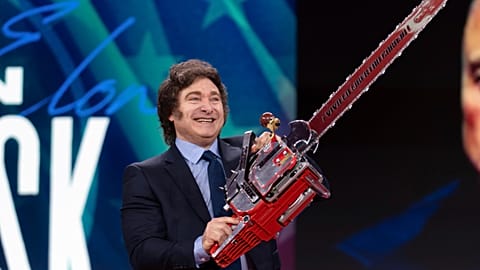 Argentina's President Javier Milei holds up a chainsaw as he arrives to speak at the CPAC conservative conference, 20 February 2025