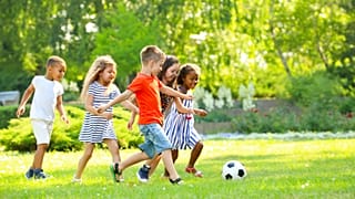 Children follow a football