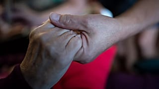 Una anciana da la mano a su hija en esta foto de archivo de 2021.