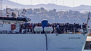 FILE - Migrants arrive in Porto Empedocle, Sicily, aboard two military ships after being transferred from the island of Lampedusa. July 27, 2020. 