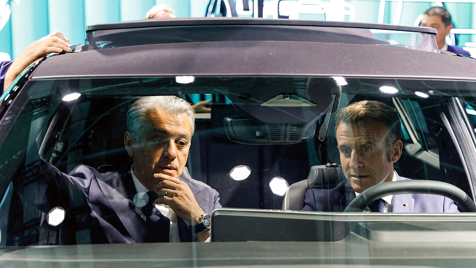 El presidente francés, Emmanuel Macro, a la derecha, y el director general de Renault, Luca De Meo, se sientan en un automóvil exhibido en el Salón del Automóvil de París