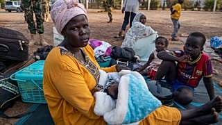سودانية تحمل طفلها البالغ من العمر شهرا واحدا تحت شجرة مع أطفالها الثلاثة الآخرين ، في مقر قوات الدفاع الشعبي لجنوب السودان في جوبا ، جنوب السودان ، يوم الجمعة ، يناير. 17, 20