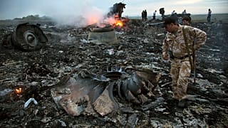 DOSSIER - Des personnes marchent parmi les débris sur le site du crash d'un avion de ligne près du village de Hrabove, en Ukraine, le 17 juillet 2014.