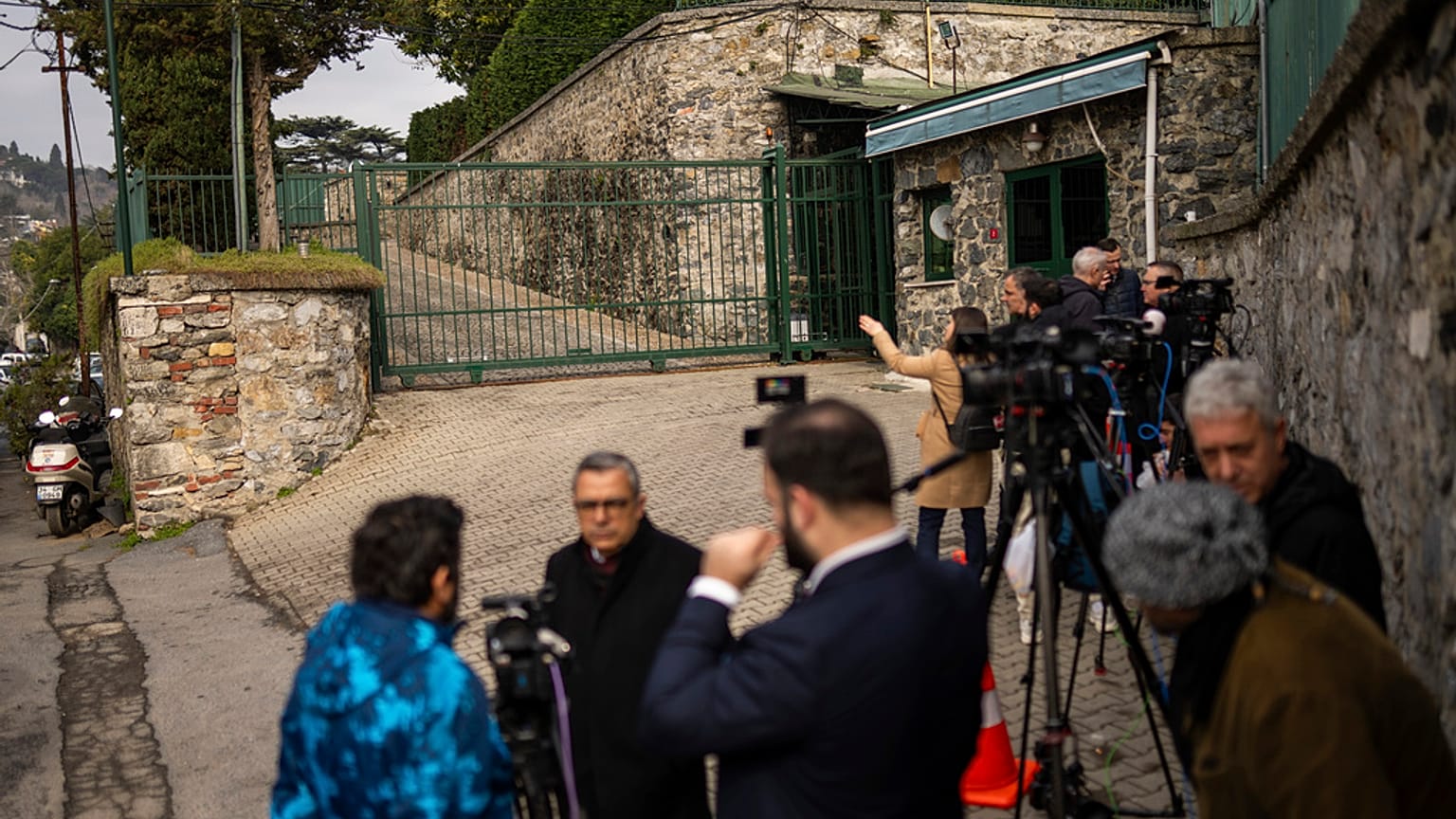 Jornalistas trabalham à porta da residência do cônsul-geral dos EUA, onde diplomatas russos e norte-americanos se encontram para discutir o funcionamento das embaixadas