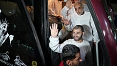 أسرى فلسطينيون يلوحون من داخل حافلة أثناء وصولهم إلى قطاع غزة بعد الإفراج عنهم من سجن إسرائيلي، في خان يونس، قطاع غزة، 27 شباط/فبراير 2025.