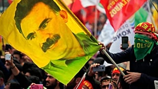 Nesta foto de arquivo datada de quarta-feira, 21 de março de 2018, um jovem segura uma bandeira com a imagem de Abdullah Ocalan, o líder do PKK