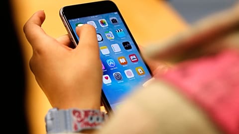 Young girl scrolling a smartphone.