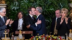 Der portugiesische Präsident Marcelo Rebelo de Sousa und der französische Präsident Emmanuel Macron umarmen sich nach ihren Reden während eines Staatsdinners im Ajuda-Nationalpalast in Lissabon