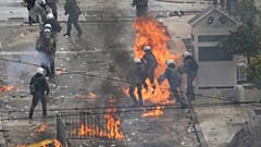 Griechische Polizeikräfte versuchen, Molotowcocktails abzuwehren, die von maskierten Männern bei der Kundgebung zum zweiten Jahrestag der Tempi-Tragödie vor dem Parlament geworfen wurden