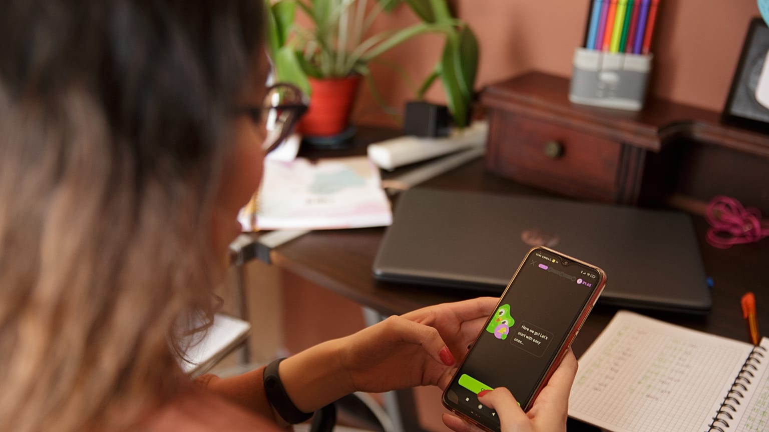 Akıllı telefonunda Duolingo uygulaması açık olan bir kadın. 