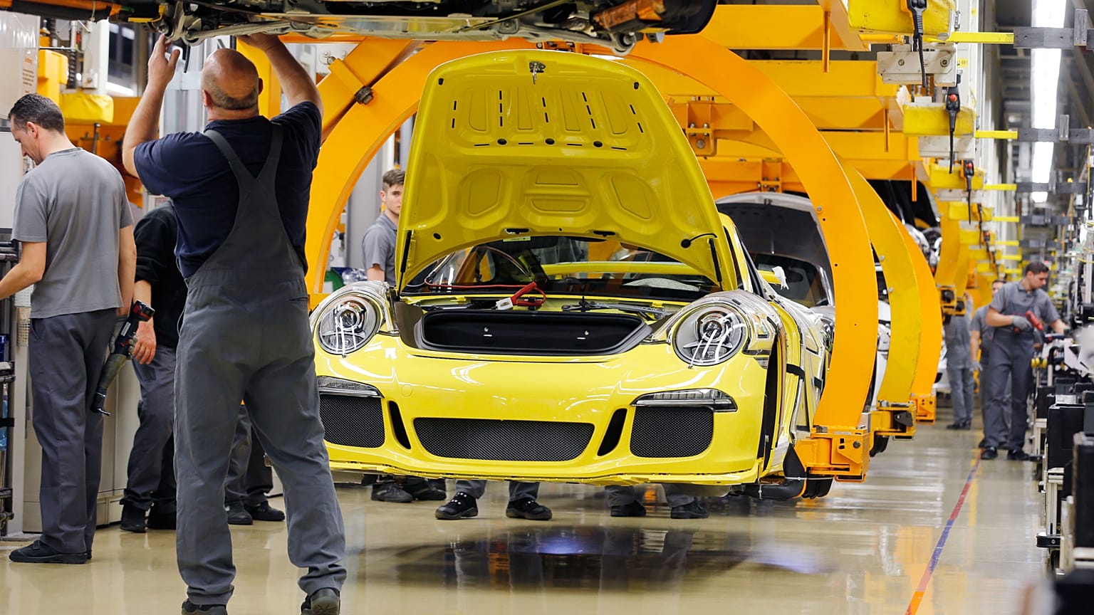 An employee works at a Porsche 911during a press tour at the Porsche manufacturing plant in Stuttgart, Germany, Tuesday, March 10, 2015. 