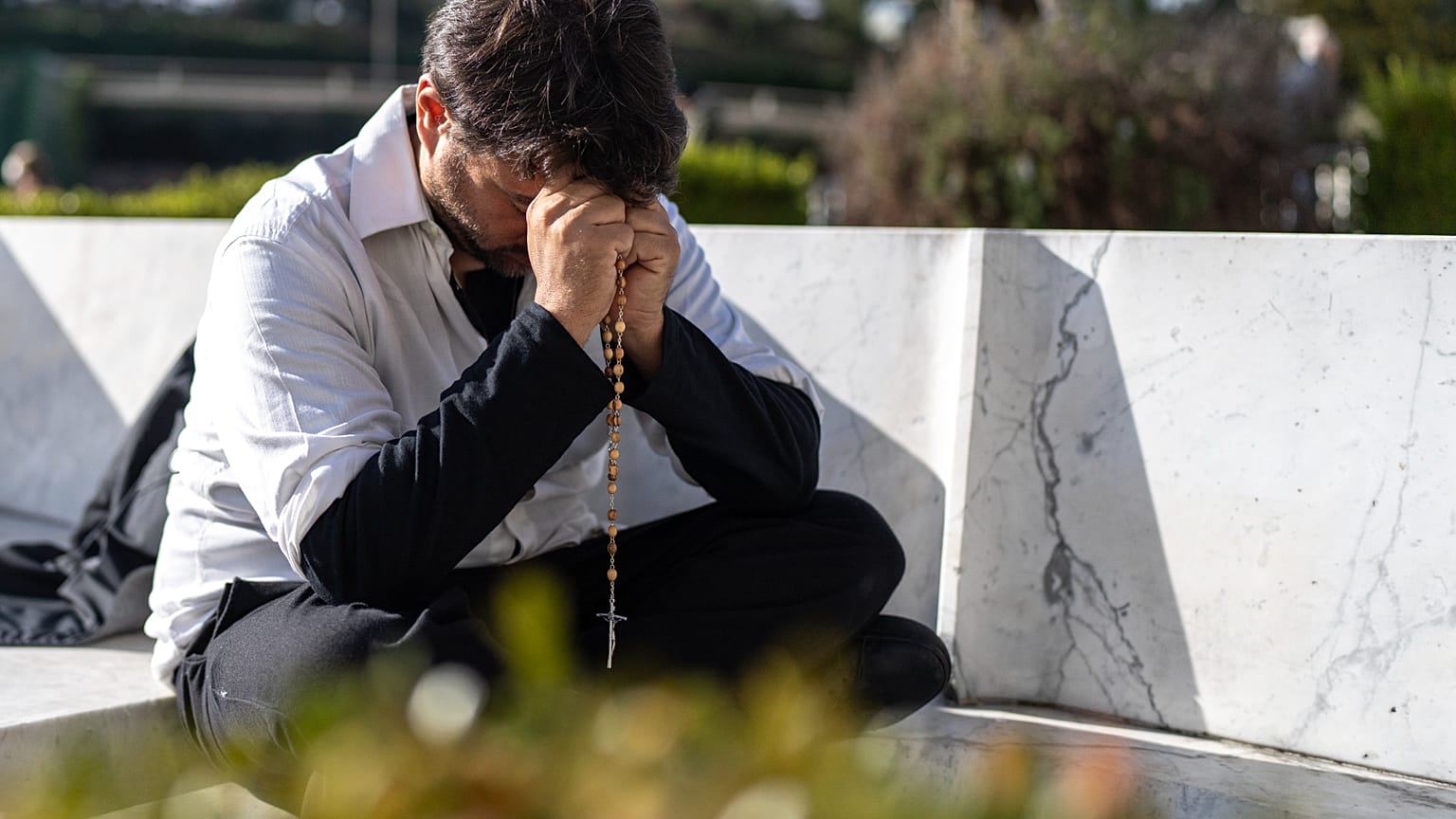 Un fedele prega fuori dal Policlinico Gemelli, dove il Papa è ricoverato: Francesco ha subito una nuova crisi respiratoria