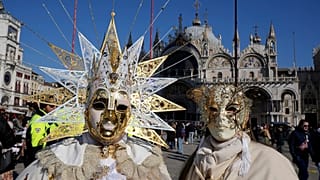 Revellers participate in the celebrations of the historic Venetian Carnival in front of St. Mark's Basilica in Venice, Italy, Saturday, Feb. 15, 2025.