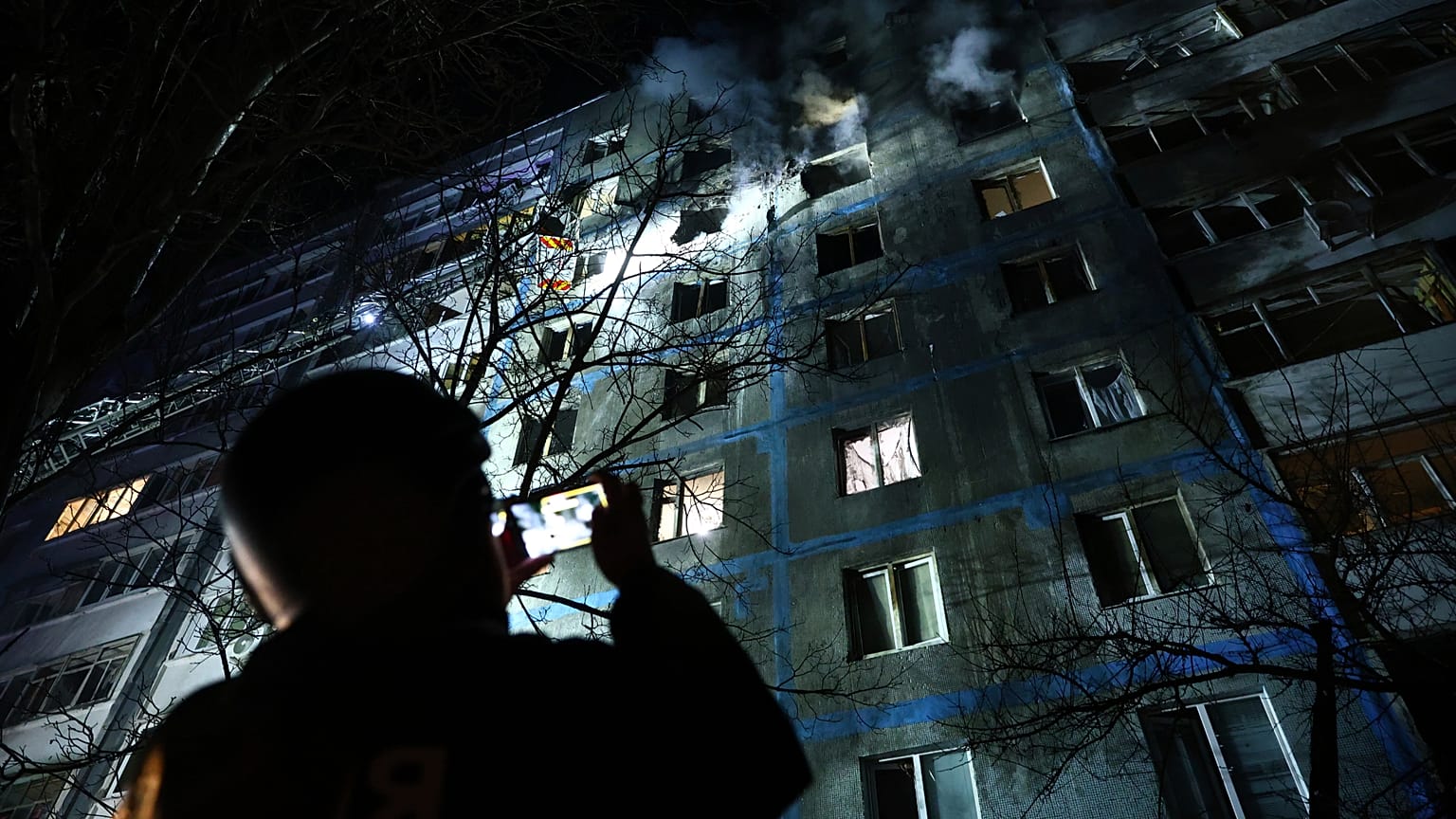 Un socorrista toma una foto de un edificio de varias plantas dañado por un ataque de drones rusos contra un barrio residencial de Zaporizhzhia, 28 de febrero de 2025.