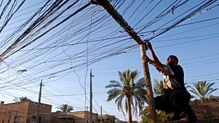 ده ها کابلی که خانه‌های محله را به ژنراتوری در بغداد وصل می‌کند، ۲۰۰۴ میلادی 