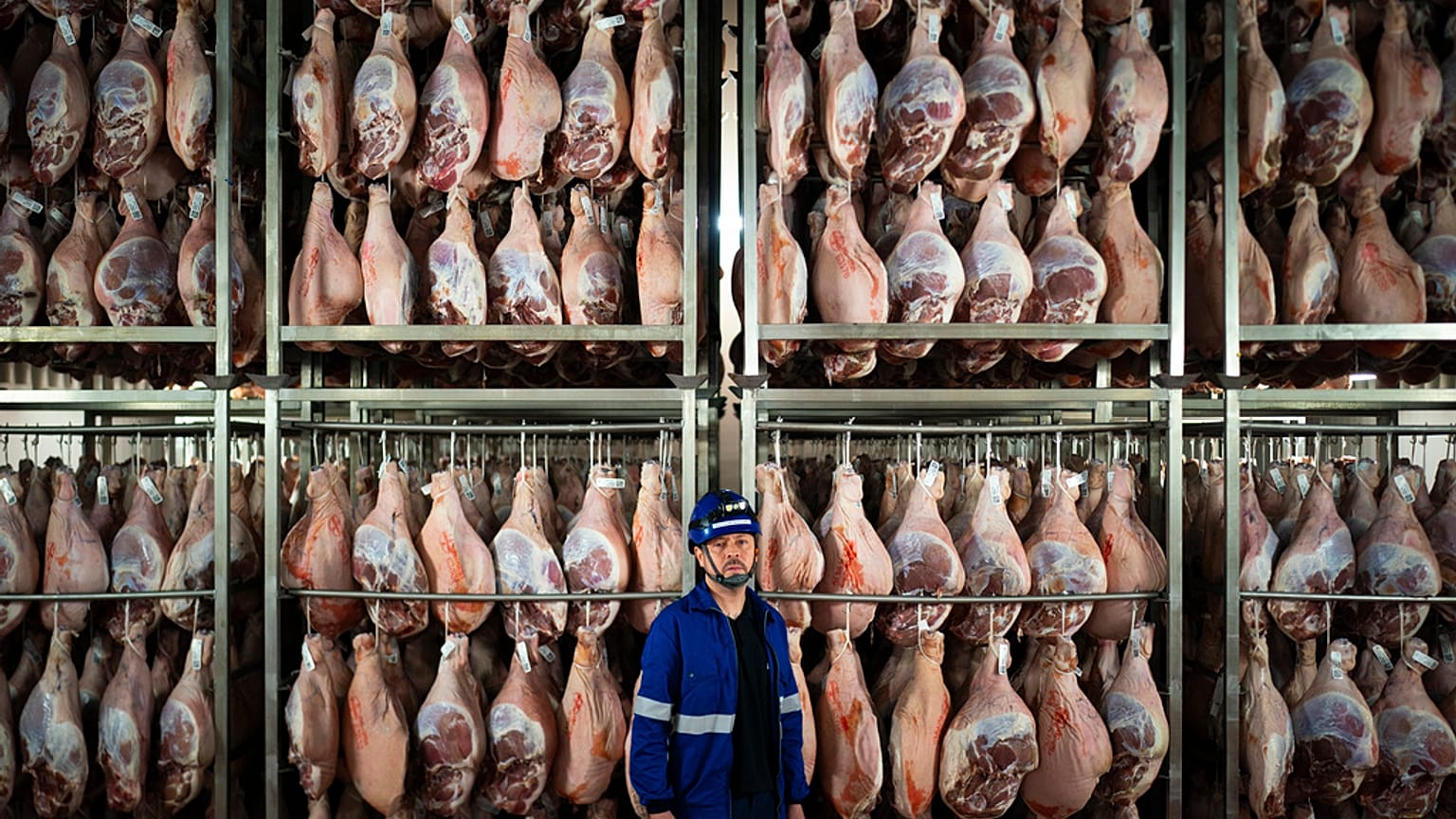 Víctor Razuri, 41 ans, originaire du Pérou, pose dans une usine de séchage de jambon à Guissona, Lleida, Espagne,