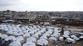 مخيم خيام للنازحين الفلسطينيين بجوار منازل ومبانٍ مدمرة في مدينة غزة، قطاع غزة، السبت، 1 آذار/مارس 2025.