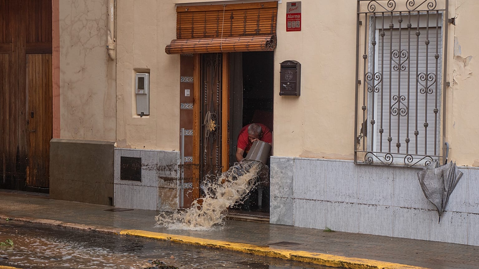 Un hombre achica agua en Valencia en una imagen de archivo de las inundaciones por la anterior DANA