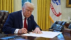 FILE - President Donald Trump signs a document in the Oval Office at the White House, 30 January 2025