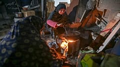Fatima Al-Absi, Ramazan'ın ilk günü Gazze Şeridi'nin kuzeyindeki Jabaliya'daki hasarlı evlerinde ailesinin iftar yemeği için yemek hazırlıyor.