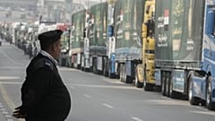 DOSYA: Kahire'de bir park noktasında Gazze'ye insani yardım taşıyan kamyonların önünde duran bir Mısır polisi, 26 Ocak 2025