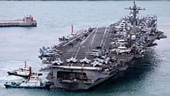 USS Carl Vinson uçak gemisi 2 Mart 2025, Pazar günü Güney Kore'nin Busan kentindeki bir donanma limanına girerken eşlik ediliyor. 