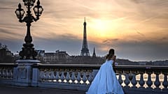 Bir kadın, 18 Şubat 2025, Salı günü, Fransa'nın başkenti Paris'te, Alexandre III Köprüsü üzerinde, arka planda Eyfel Kulesi ile birlikte poz veriyor.
