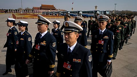 Military delegates march in formation to the Great Hall of the People to attend a preparatory session of the National People's Congress in Beijing, Tuesday, March 4, 2025. (AP