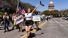 Nicole Surginer schwenkt eine ukrainische Flagge während eines Protestes gegen die Politik der Trump-Administration in Downtown Austin, Dienstag, 4. März 2025 