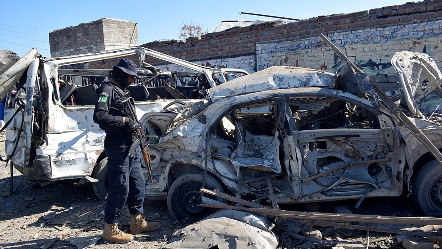 Un officier de police examine les véhicules endommagés sur le site de l'attentat suicide de mardi, à Bannu, dans le nord-ouest du Pakistan, mercredi 5 mars 2025.