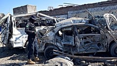 Ein Polizeibeamter untersucht die beschädigten Fahrzeuge am Ort des Selbstmordattentats vom Dienstag in Bannu, im Nordwesten Pakistans, Mittwoch, 5. März 2025.