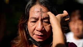 Une dévote avec une croix de cendre sur le front prie lors des rites du Mercredi des Cendres le 5 mars 2025 à l'église rédemptoriste de Manille, Philippines.