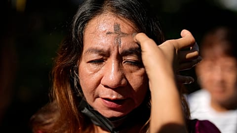 Une dévote avec une croix de cendre sur le front prie lors des rites du Mercredi des Cendres le 5 mars 2025 à l'église rédemptoriste de Manille, Philippines.