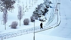 Eine Frau spaziert am Goldenen Horn nach einem Schneefall in Istanbul, Türkei, Freitag, 21. Februar 2025. 