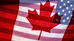 Солнечный свет пробивается сквозь флаги Канады и США, которые держит вместе протестующий на Парламентском холме в Оттаве, 1 февраля 2025 года.