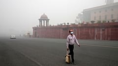 Un peatón lleva una mascarilla en medio de una espesa capa de smog en Nueva Delhi, India.