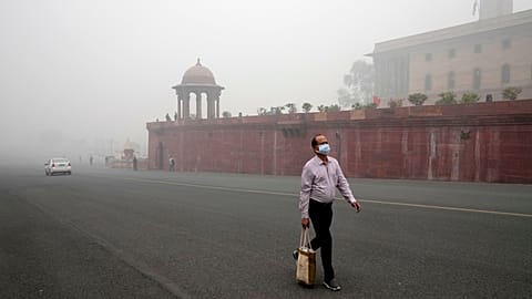 A pedestrian wears a face mask amidst a thick layer of smog in New Delhi, India.