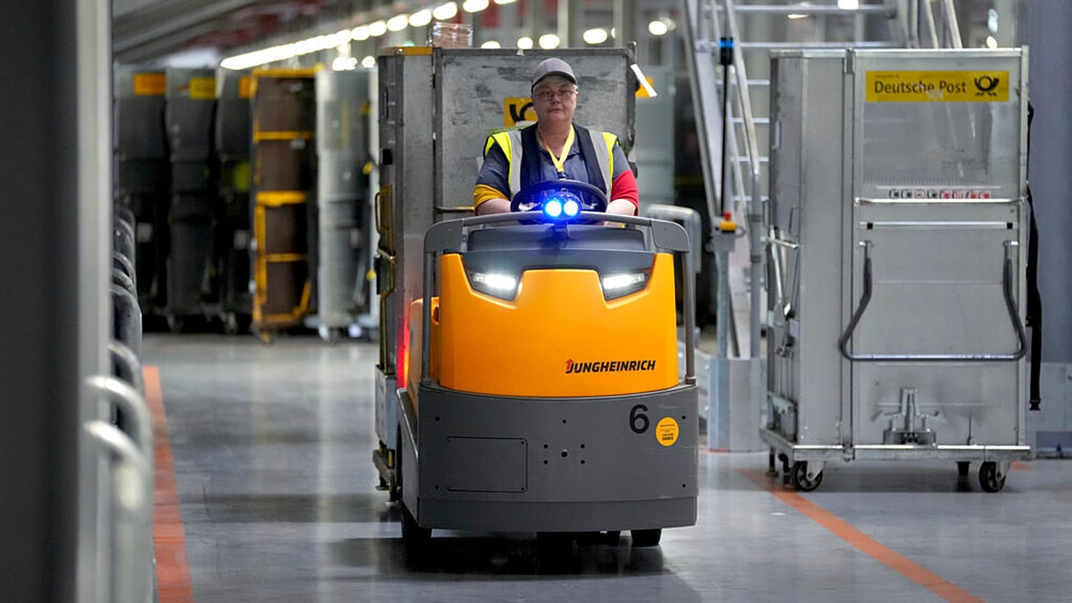 A staff member drives a transport vehicle at the DHL Mega Parcel Center in Ludwigsfelde near Berlin, Germany, Tuesday, May 31, 2022.