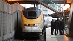 Eurostar-Mitarbeiter unterhalten sich auf dem Bahnsteig, während ein Eurostar-Zug den Bahnhof Gare du Nord in Paris verlässt, Dienstag, 22. Dezember 2009.