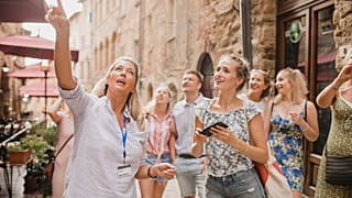 Mujeres disfrutan de un recorrido por las calles de Volterra, Italia