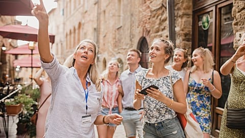 Women enjoy a tour through the city streets of Volterra, Italy