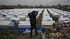 پسری روز جمعه هفتم مارس ۲۰۲۵ در محله زیتون شهر غزه به چادرهای تازه برپا شده فلسطینی‌های آواره در میان خانه‌های ویران شده در اثر حملات ارتش اسرائیل نگاه می‌کند.