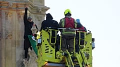 Emergency services talk to a man with a Palestinian flag after he climbed up Elizabeth Tower, March 8th 2025